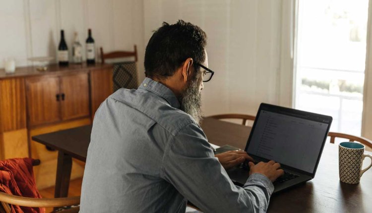 man achter laptop