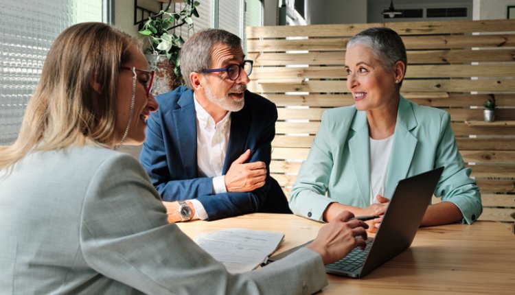Drie ouderen bespreken samen financiele zaken, notaris