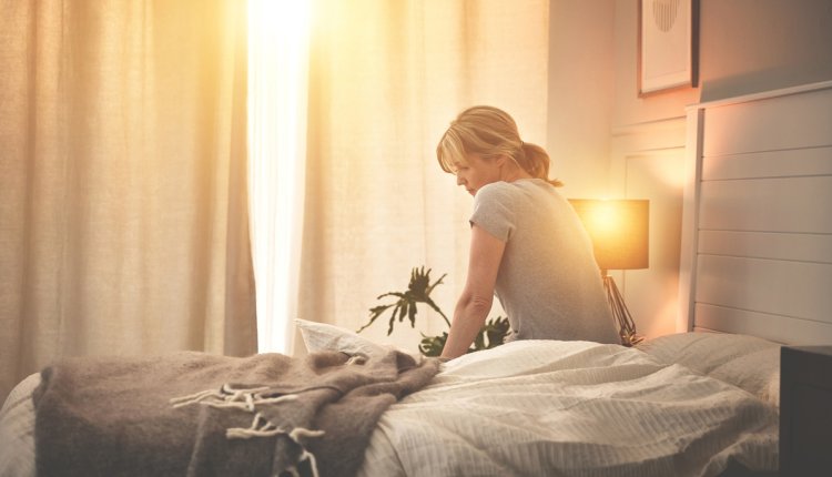 Vrouw op bed, net wakker maar niet uitgerust