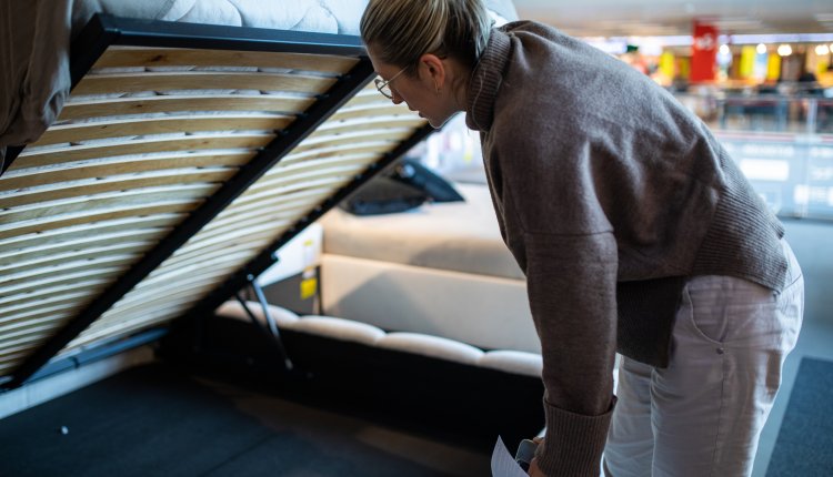 Vrouw kijkt naar lattenbodem in winkel voor bedden