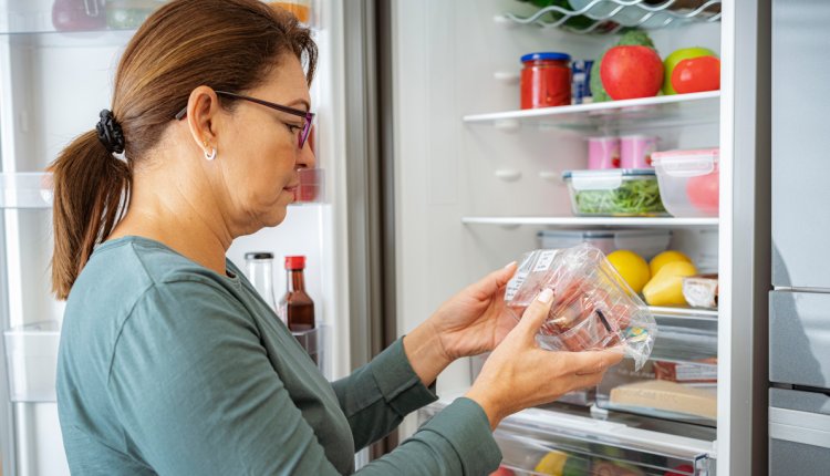 Vrouw checkt houdbaarheidsdatum van een verpakking