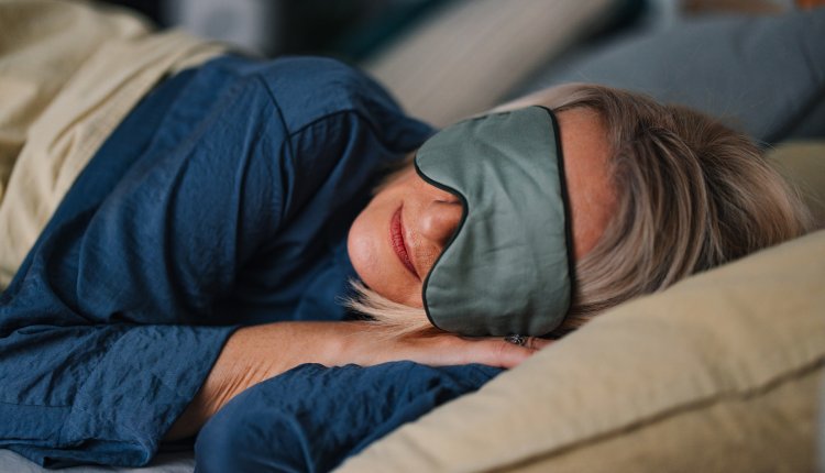 Vrouw ligt te slapen met slaapmasker op
