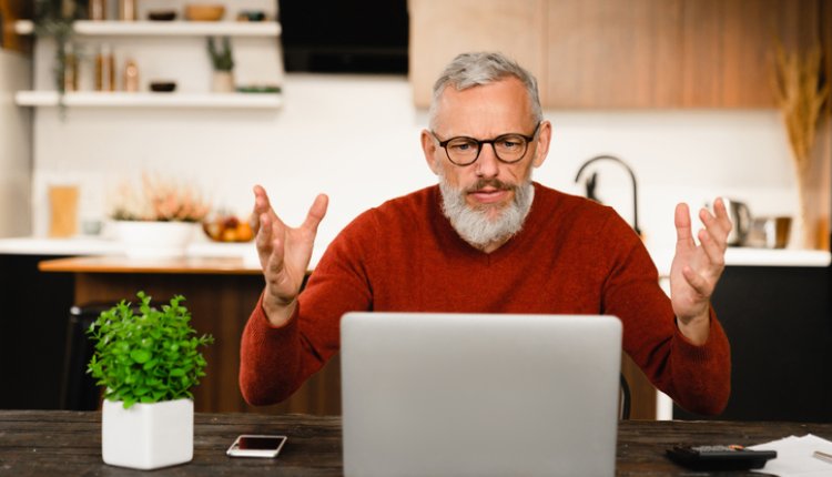 Man zit vertwijfeld achter laptop