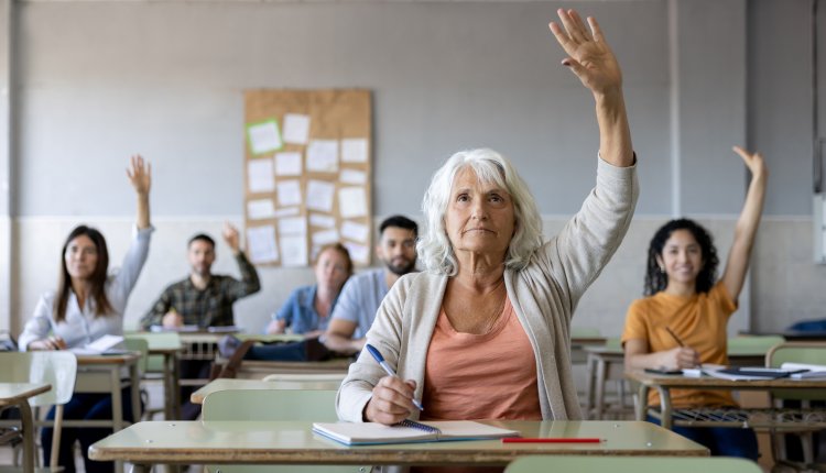 Oudere vrouw steekt hand op