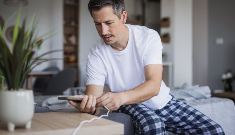 Man legt telefoon aan oplader