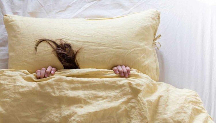 Pluk haar steekt onder dekbed uit