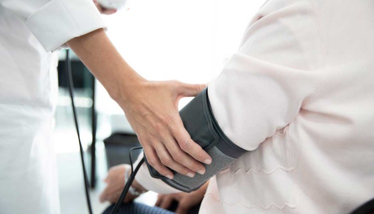 Bloeddruk wordt opgemeten bij een vrouw 