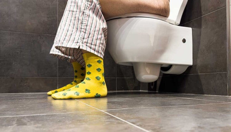 Man zittend op toilet