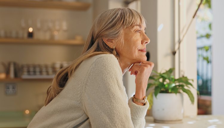 oudere vrouw kijkt uit raam