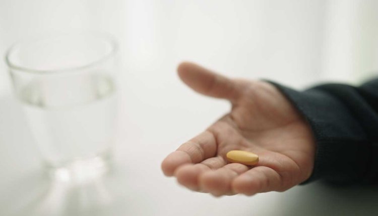 Vrouw met een vitamine c supplement in haar hand