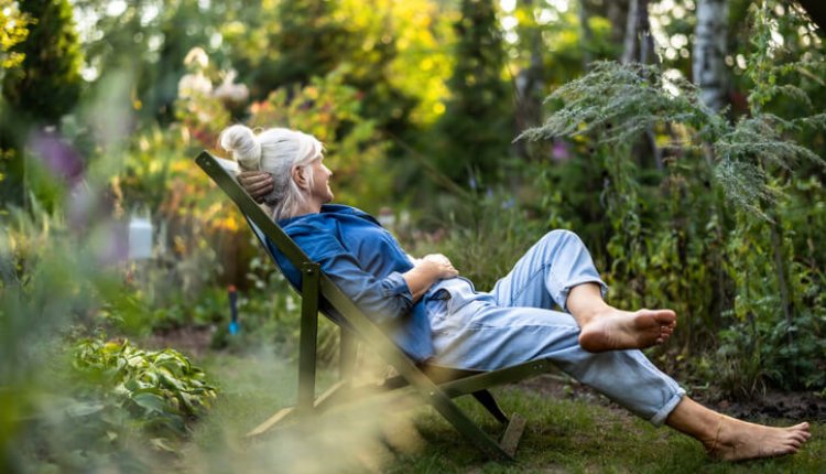 Oudere dame in tuinstoel