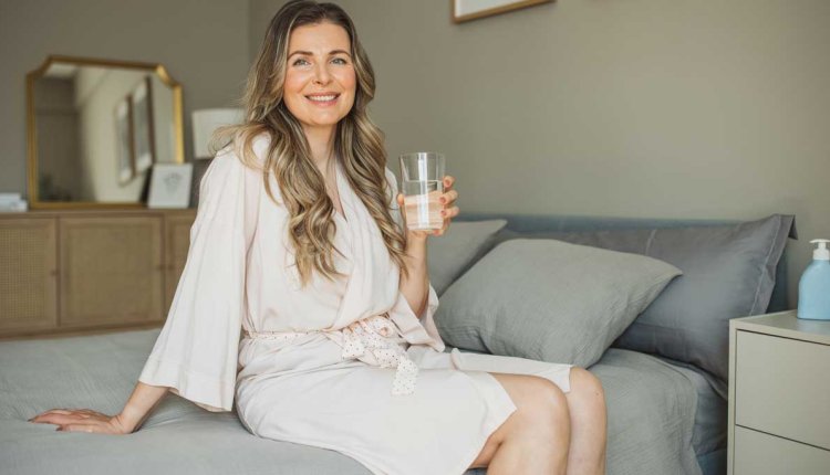 vrouw op bed in badjas