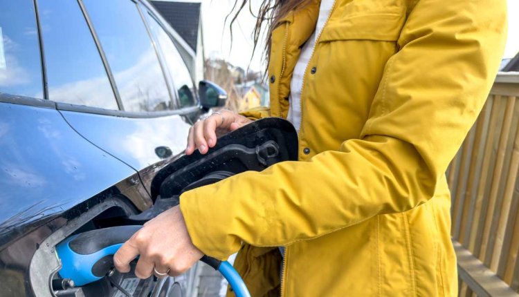 Vrouw laadt elektrische auto op