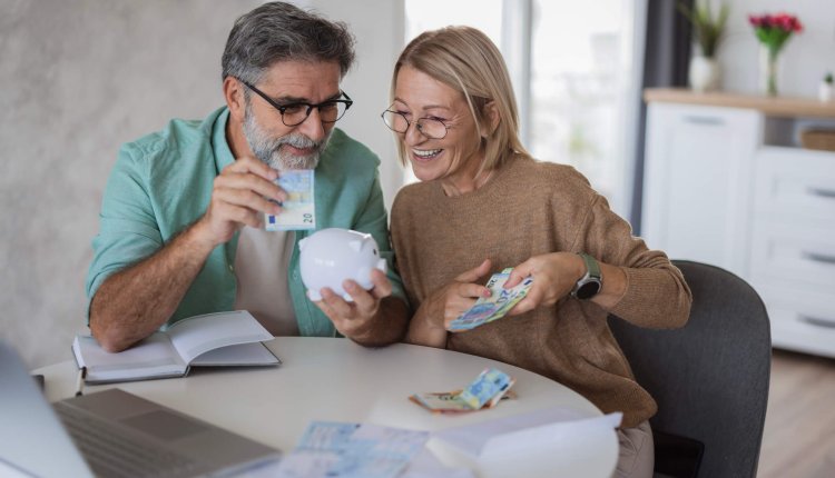 Ouderen tellen hun geld in de keuken met spaarvarken