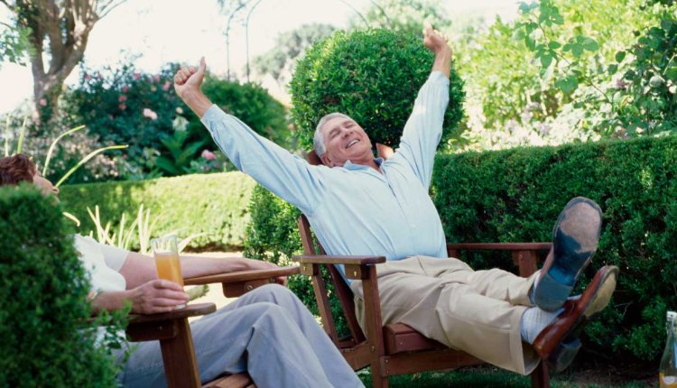 Man in zijn achtertuin juichend omdat hij met pensioen is