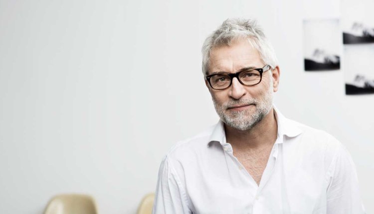 Man van middelbare leeftijd met grijs haar en een wit overhemd