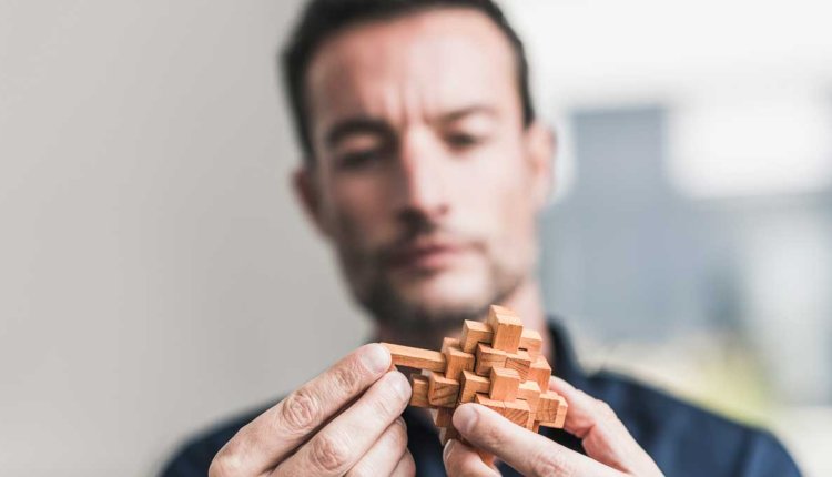 Man doet houten puzzeltje