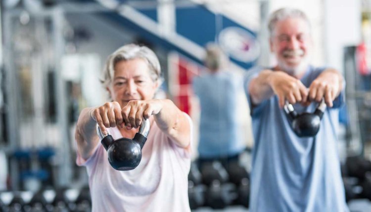 Twee fitte senioren trainen met gewichten