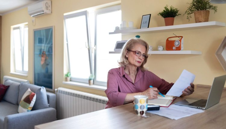 Vrouw is thuis bezig met de administratie