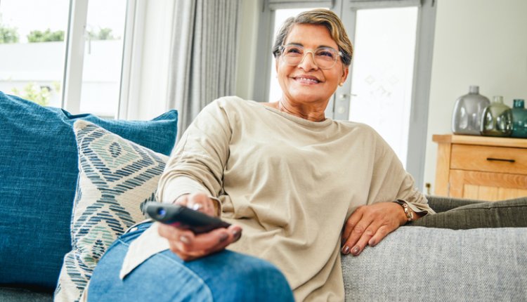 Vrouw kijkt TV op de bank