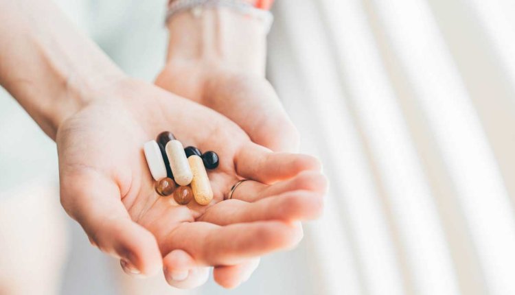 Handen met vitaminepillen