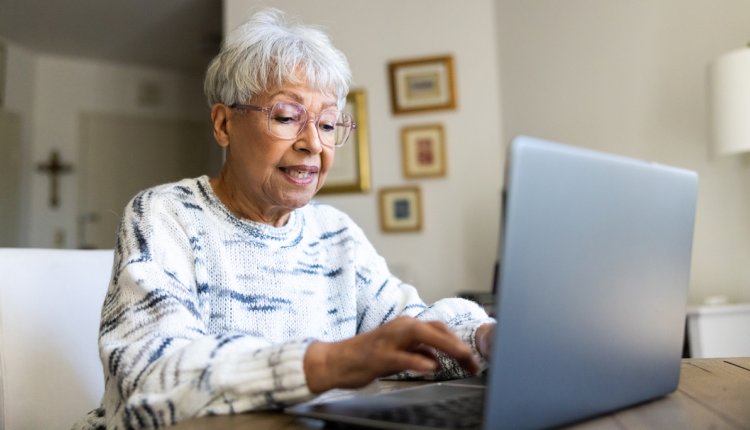 oudere vrouw typt op laptop