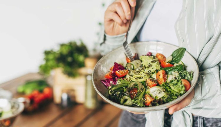 Vrouw eet gezonde salade met verse ingrediënten
