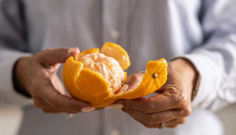 vrouw pelt mandarijn