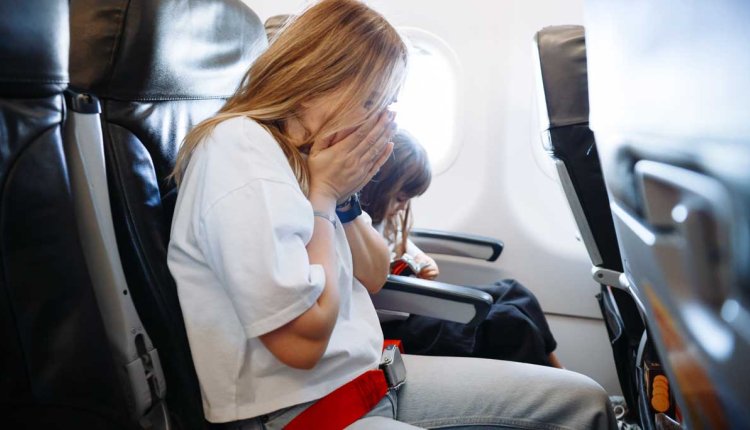 Vrouw met reisziekte in het vliegtuig