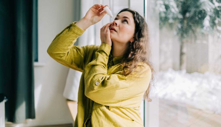 Vrouw druppelt haar ogen