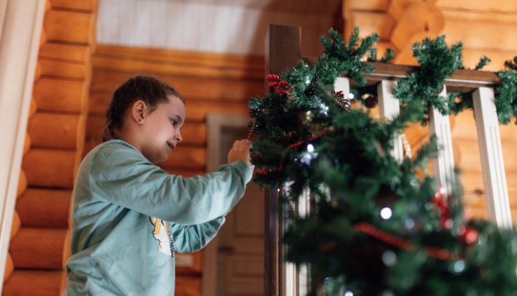 Vrouw is bezig de kerstboom te versieren