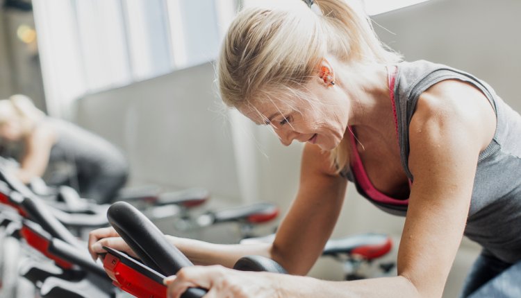 oudere vrouw doet aan spinning