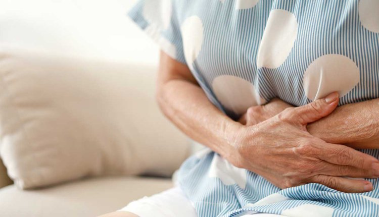 Vrouw met handen op haar pijnlijke buik