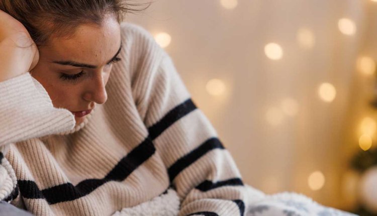 Vrouw op de bank met een winterdip, heeft nergens zin in
