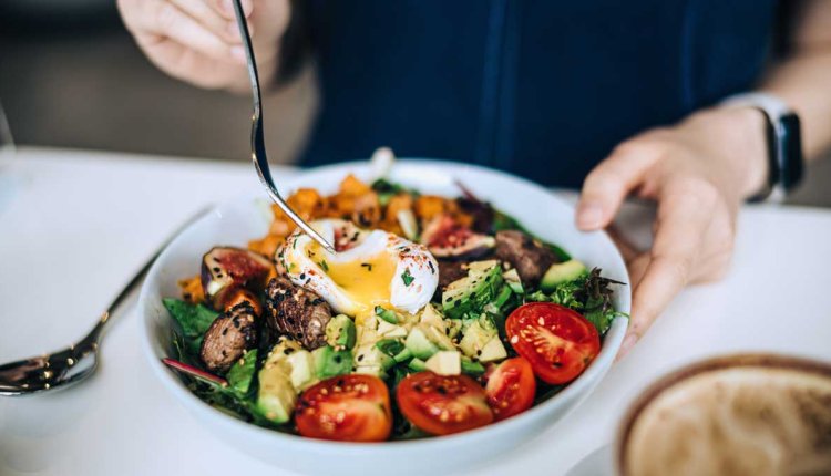 Vrouw eet gezonde koolhydraatarme maaltijd