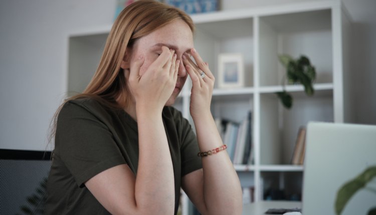 Vrouw met handen voor gezicht door computerproblemen
