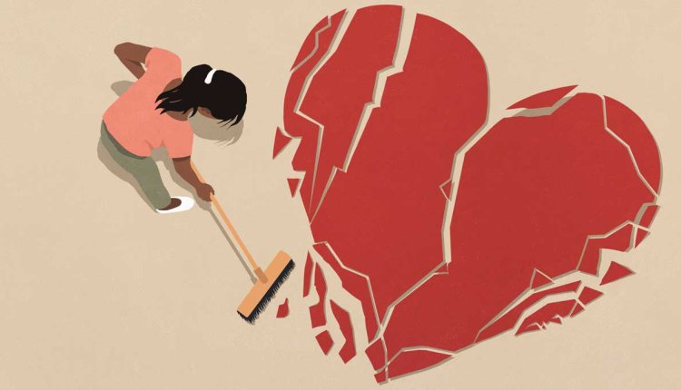 Vrouw veegt scherven van gebroken hart bij elkaar