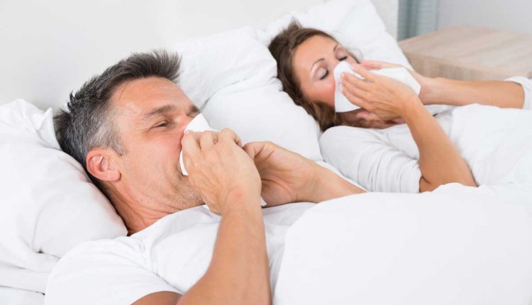 Man en vrouw liggen samen in bed met griep