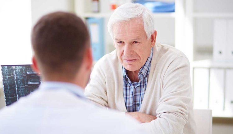 Man in gesprek met arts over zijn fysieke klachten