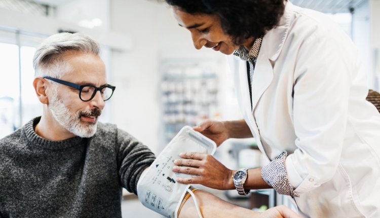 man laat bloeddruk meten door arts