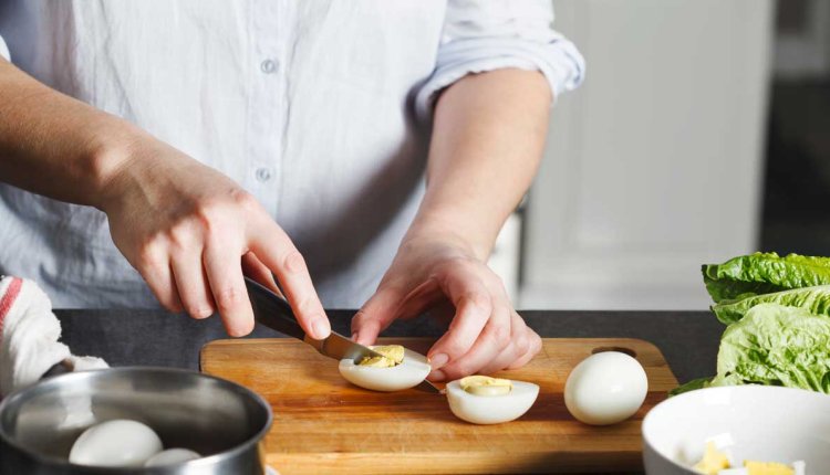 Vrouw snijdt gekookt ei