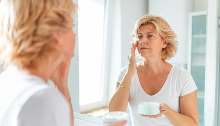 Vrouw smeert creme op haar gezicht