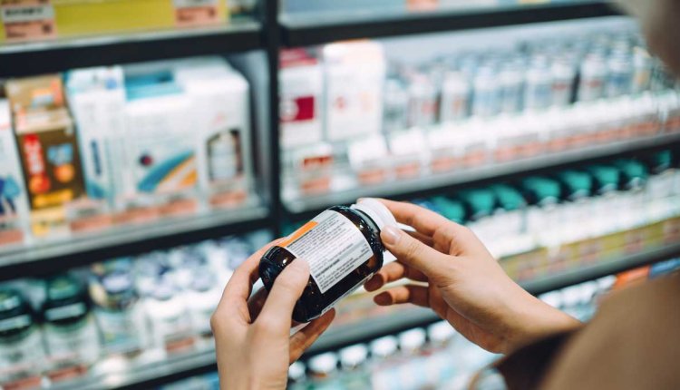 Vrouw bekijkt etiket voedingssupplement