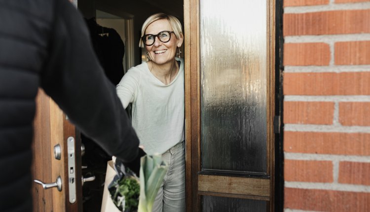 oudere vrouw krijgt boodschappen bezorgd