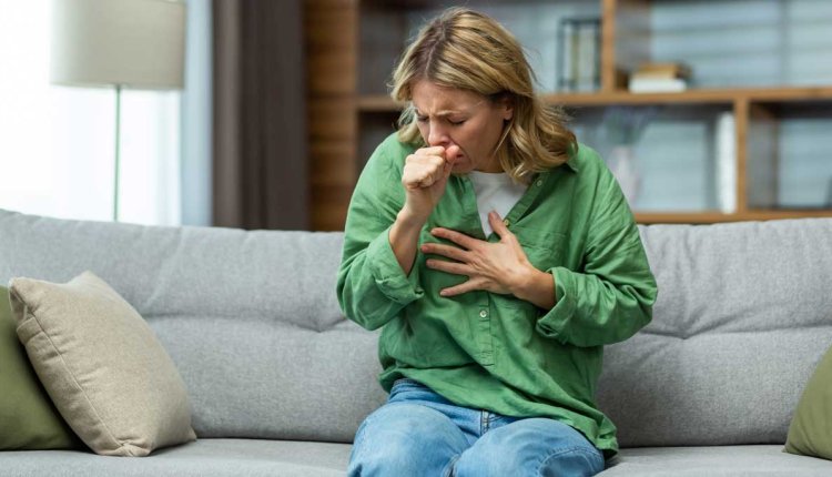 hoestende vrouw op de bank