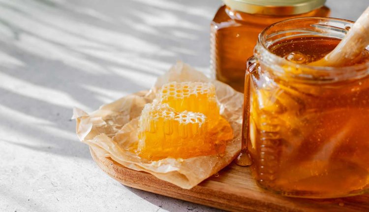 Honing in een potje op een houten plank
