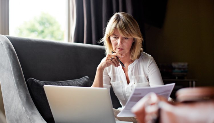 Oudere vrouw werkt achter haar laptop