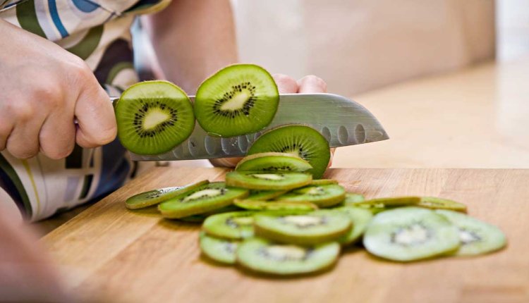 Vrouw snijdt kiwi's