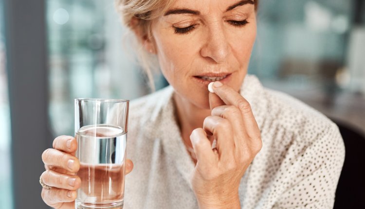 oudere vrouw slikt medicatie