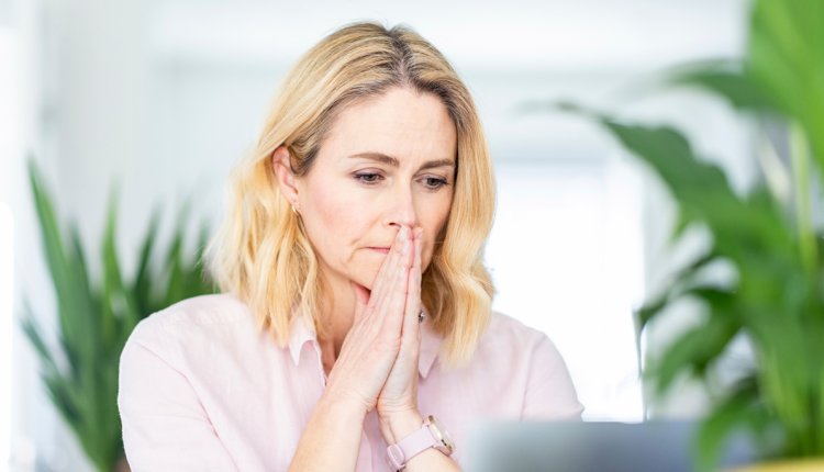 Vrouw bezorgd achter computer, zal ik inloggen of niet?